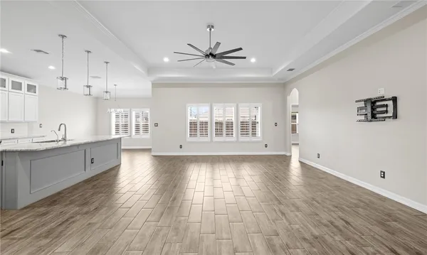 a view of an empty room with window and wooden floor