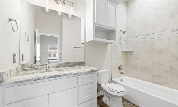 a bathroom with a granite countertop sink toilet and shower