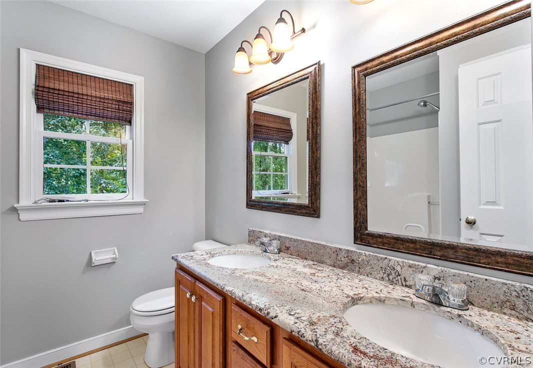 13902 Sagebrook Road Midlothian, VA 23112 - Photo 21 of 37 a bathroom with a granite countertop sink a toilet and a window