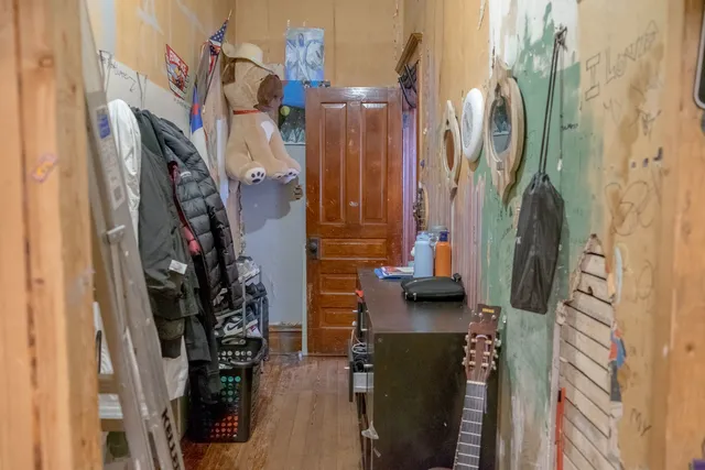 a view of a hallway with wooden floor and living room
