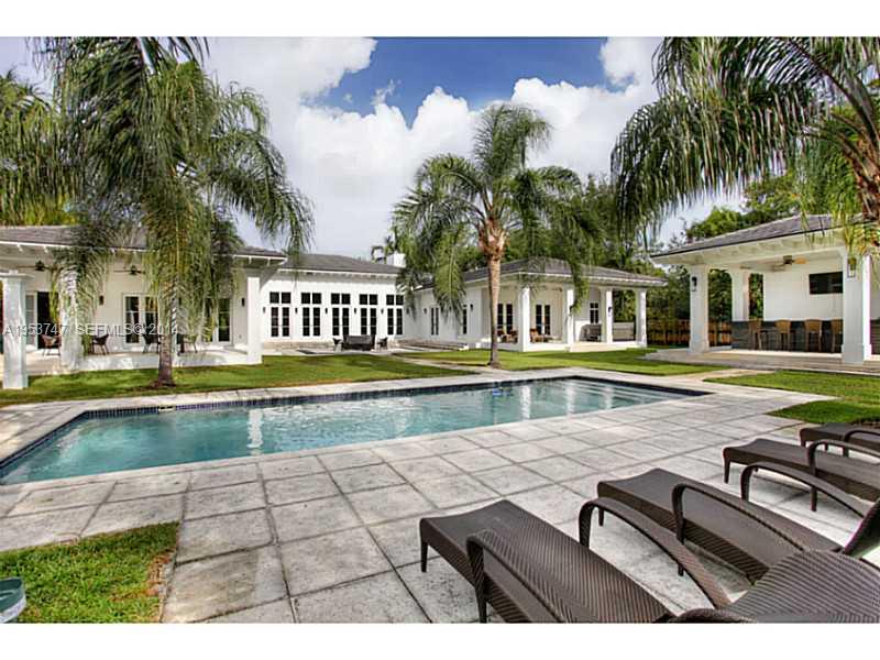 a view of swimming pool with outdoor seating and house in the background