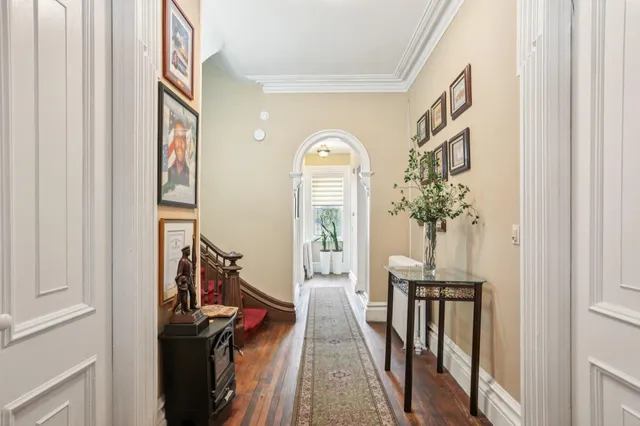 a view of a hallway with wooden floor and entryway