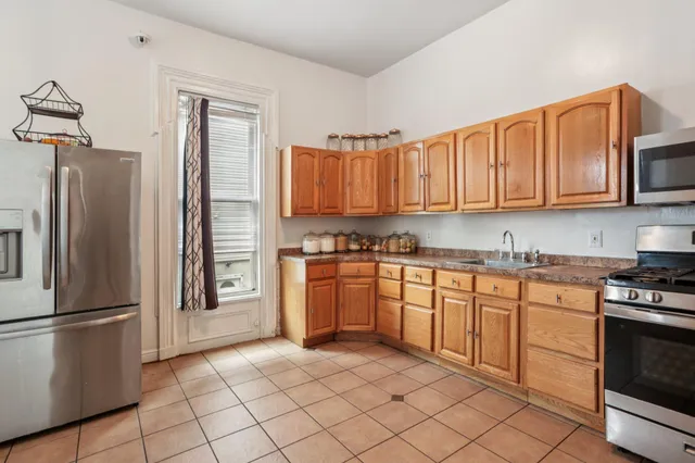 a kitchen with stainless steel appliances granite countertop a refrigerator sink and stove