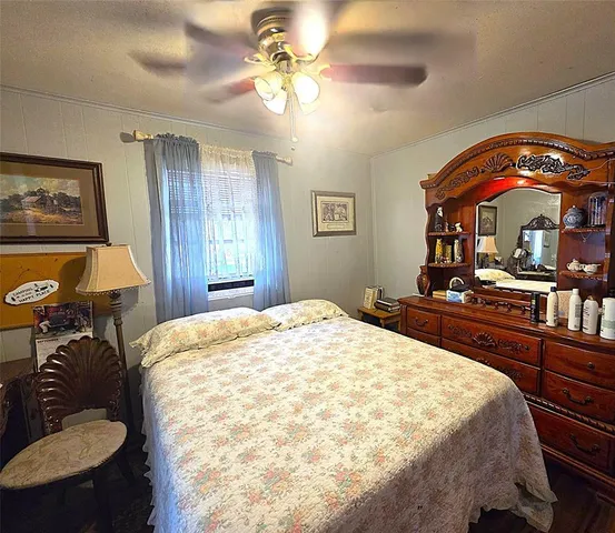 a bedroom with a bed and dresser with mirror