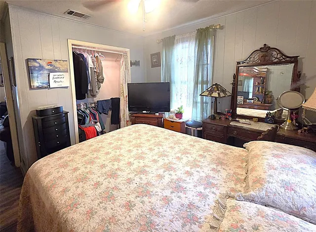 a bed room with a bed mirror and dresser