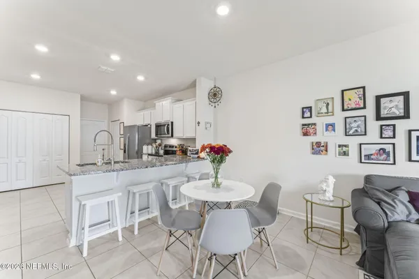 a kitchen with granite countertop white cabinets and chairs