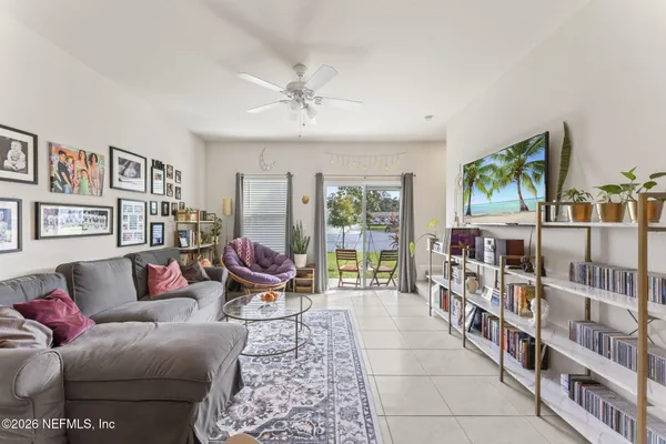 a living room with furniture lots of books and a large window