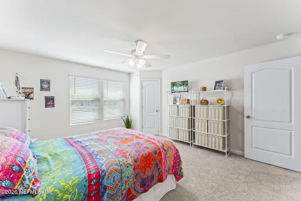a spacious bedroom with a bed a window and closet