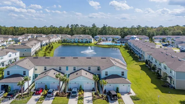 an aerial view of residential houses with outdoor space and swimming pool