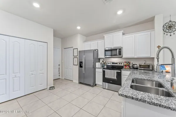 a kitchen with stainless steel appliances granite countertop a refrigerator sink and stove