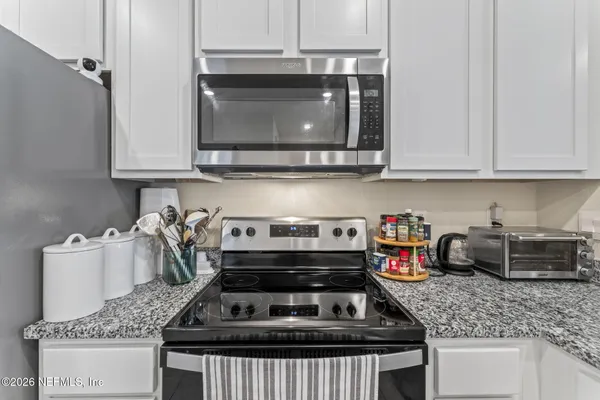 a kitchen with granite countertop a stove and a sink