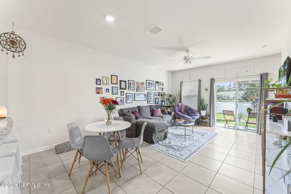 a living room with furniture and a dining table with chairs