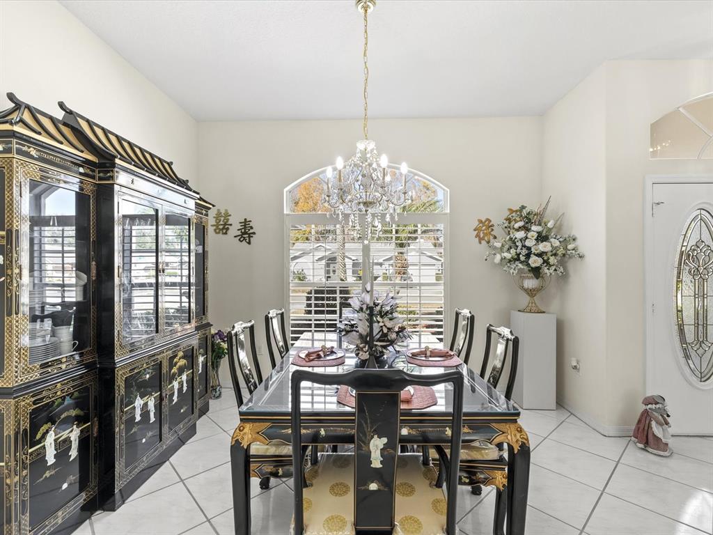 8704 Cypress Lakes Boulevard New Port Richey, FL 34653 - Photo 14 of 43 a view of a dining room with furniture and a chandelier