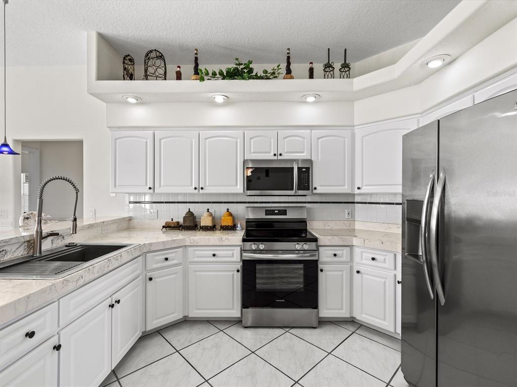 8704 Cypress Lakes Boulevard New Port Richey, FL 34653 - Photo 18 of 43 a kitchen with stainless steel appliances granite countertop a sink and cabinets