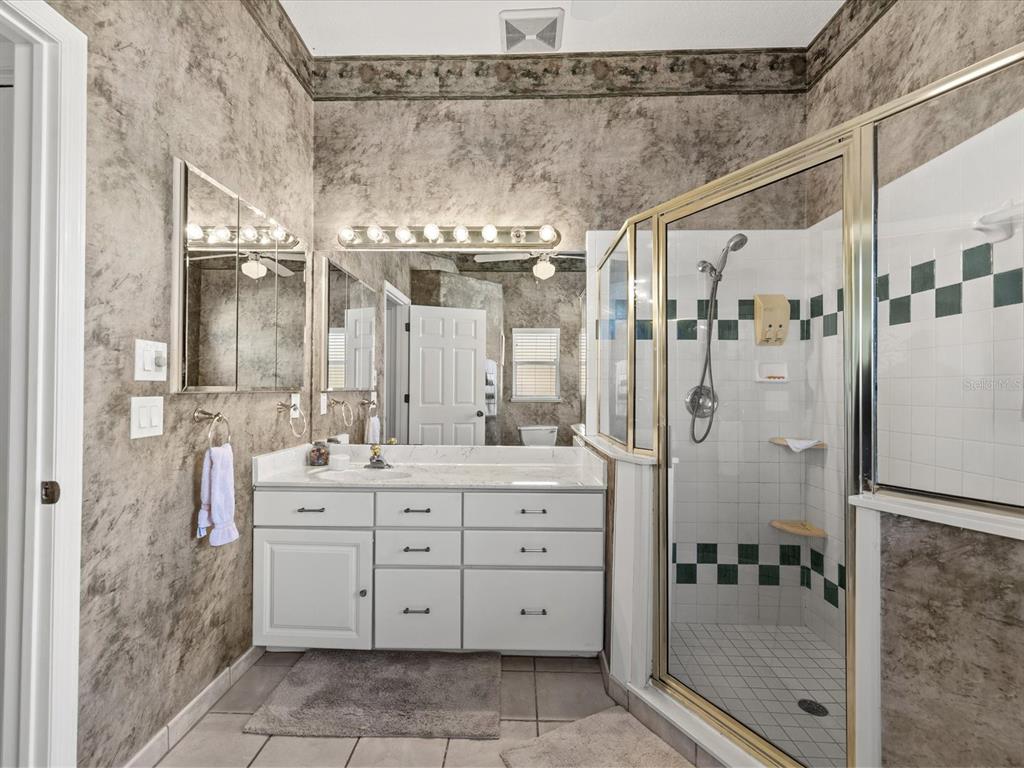 8704 Cypress Lakes Boulevard New Port Richey, FL 34653 - Photo 24 of 43 a bathroom with a double vanity sink toilet shower and bathtub