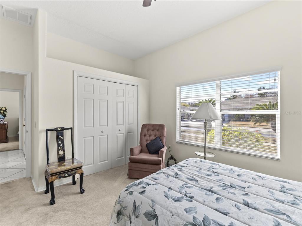 8704 Cypress Lakes Boulevard New Port Richey, FL 34653 - Photo 27 of 43 a bedroom with a bed and large windows