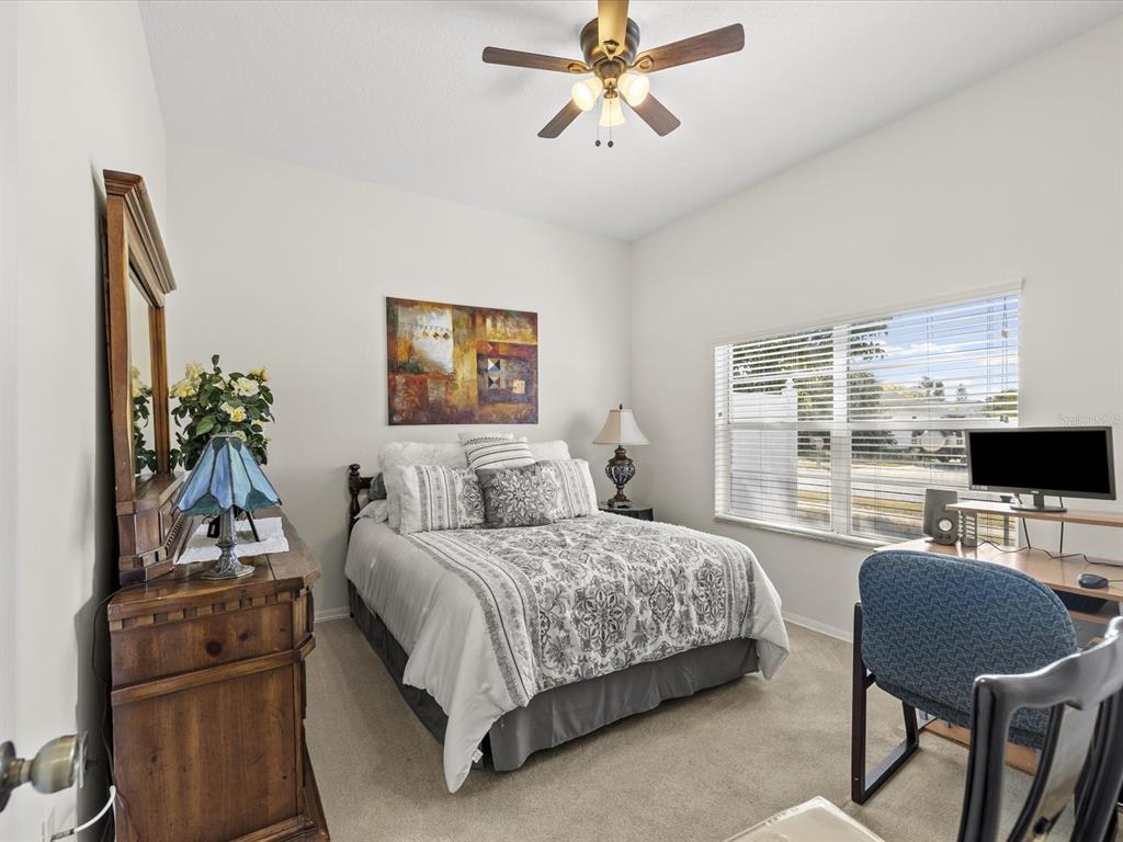 8704 Cypress Lakes Boulevard New Port Richey, FL 34653 - Photo 29 of 43 a bedroom with a bed a couch and a window