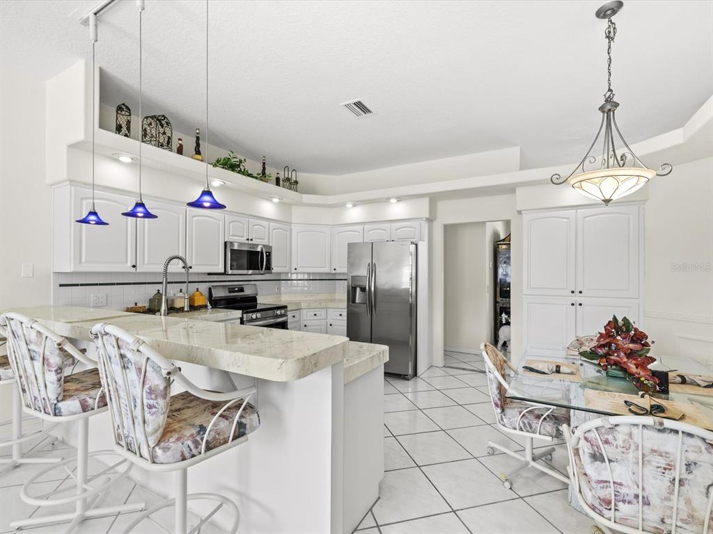 8704 Cypress Lakes Boulevard New Port Richey, FL 34653 - Photo 3 of 43 a kitchen with stainless steel appliances kitchen island granite countertop a sink and cabinets