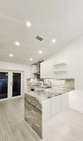 a kitchen with a refrigerator and white cabinets