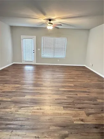 a view of empty room with wooden floor