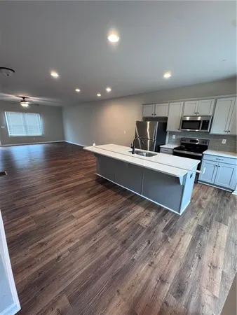 a view of kitchen with kitchen island microwave and wooden floor
