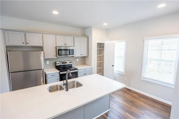 a kitchen with a refrigerator a stove a microwave and island with wooden floor
