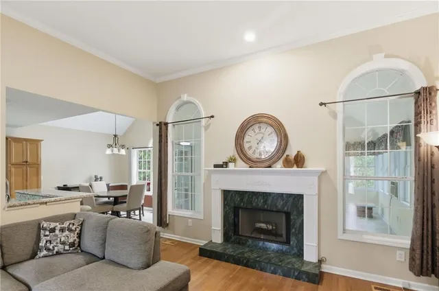 a living room with furniture a clock and a fireplace