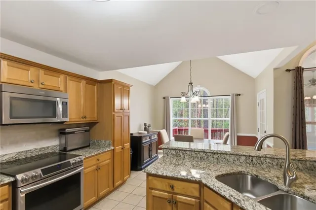 a kitchen with stainless steel appliances granite countertop a sink stove and cabinets