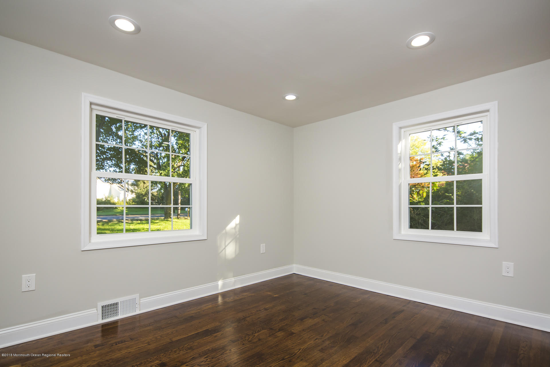 584 Colts Neck Road Freehold, NJ 07728 - Photo 18 of 29 an empty room with wooden floor and windows