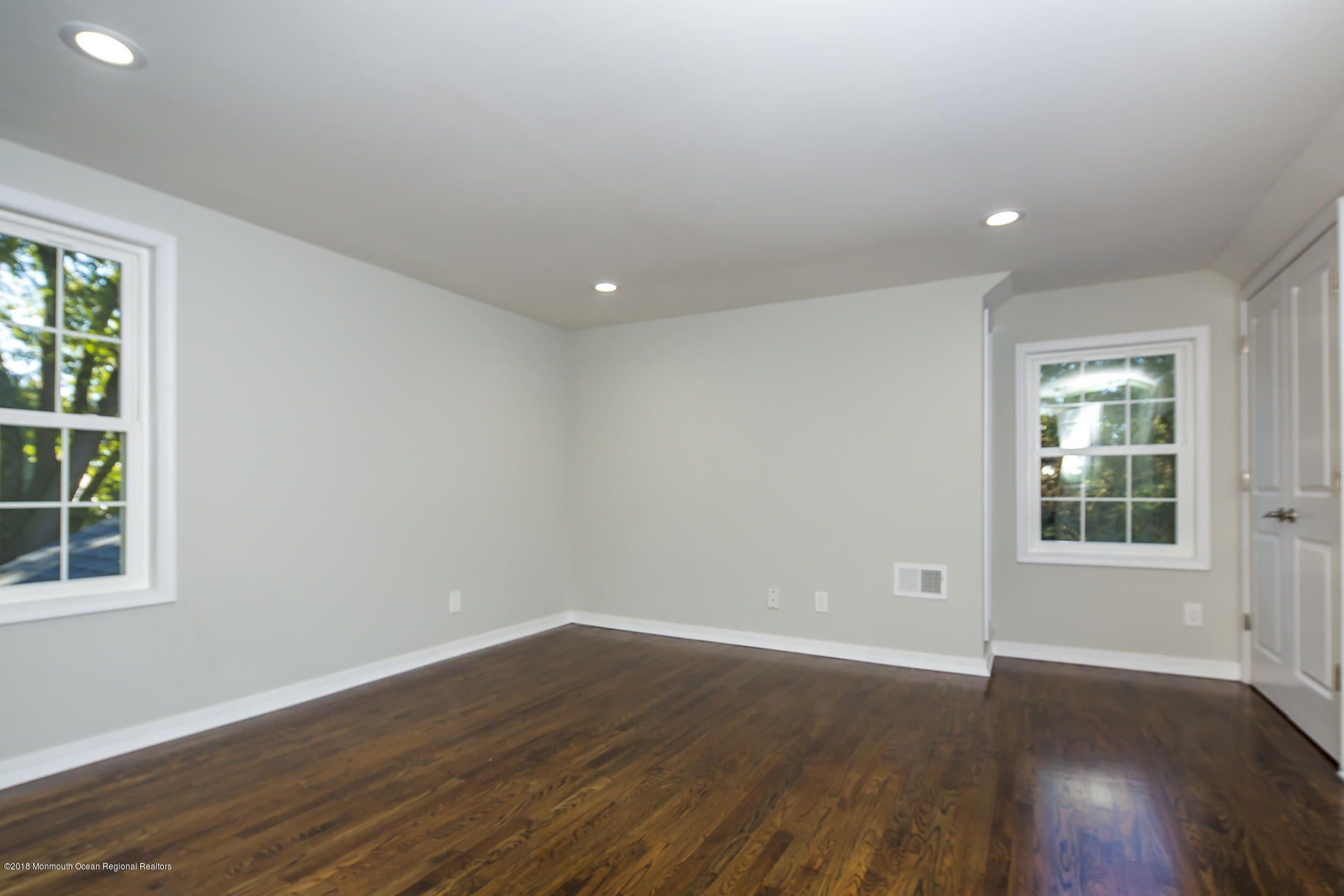 584 Colts Neck Road Freehold, NJ 07728 - Photo 19 of 29 an empty room with wooden floor and windows