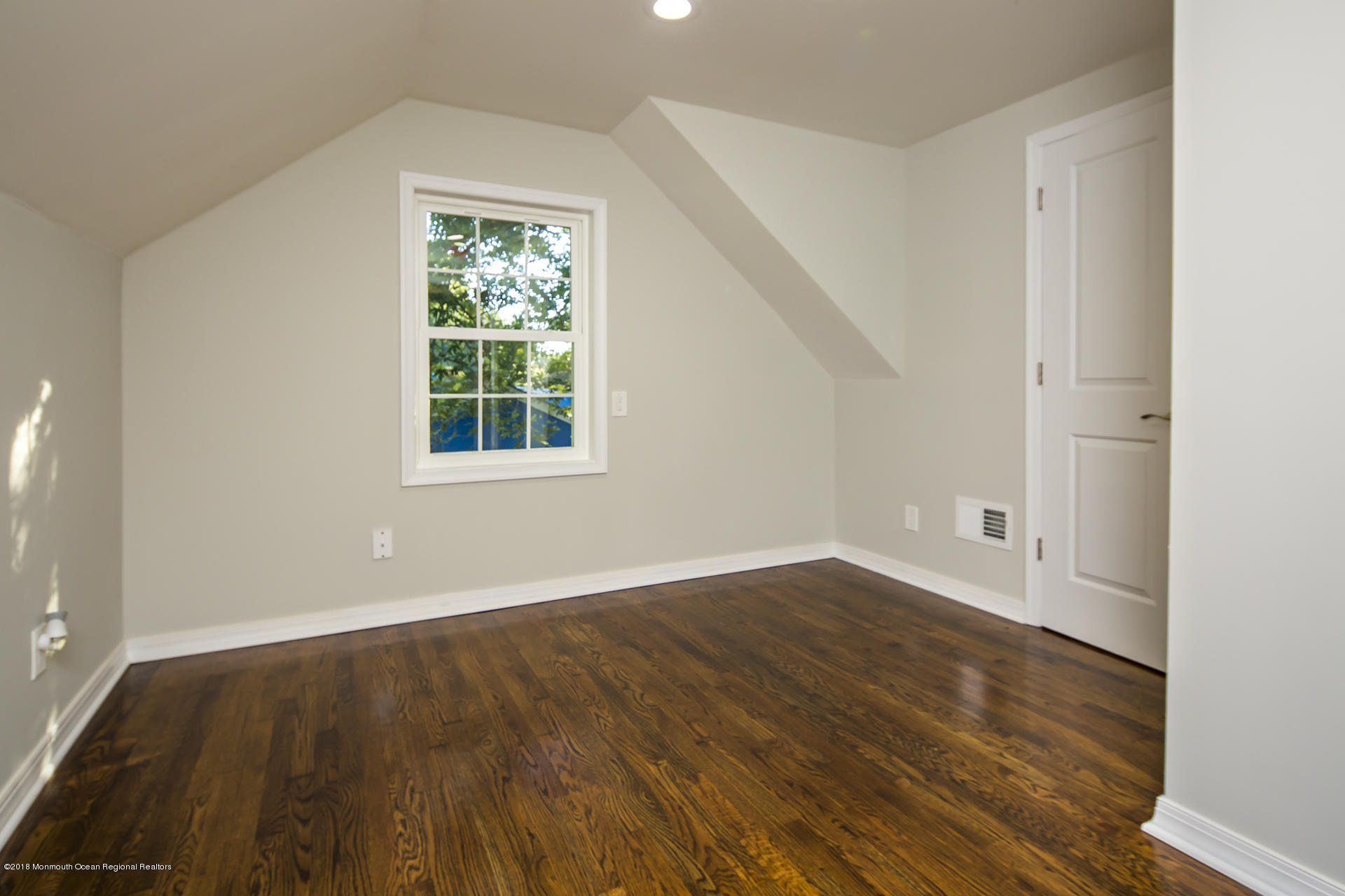 584 Colts Neck Road Freehold, NJ 07728 - Photo 22 of 29 an empty room with wooden floor and windows