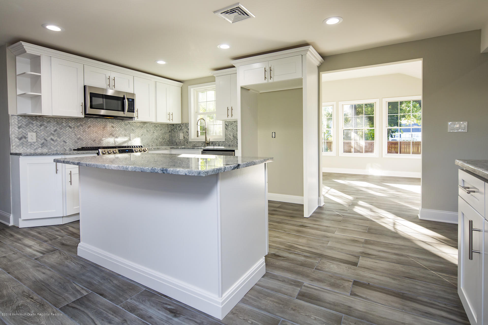 584 Colts Neck Road Freehold, NJ 07728 - Photo 9 of 29 a kitchen with stainless steel appliances granite countertop a refrigerator a stove top oven a sink dishwasher and white cabinets with wooden floor