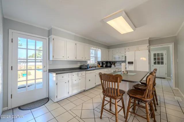 a kitchen with stainless steel appliances granite countertop white cabinets and window