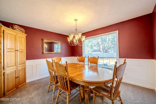 a dining room with furniture a chandelier and window