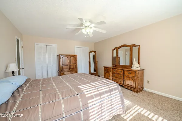 a bedroom with a bed dresser and a large mirror