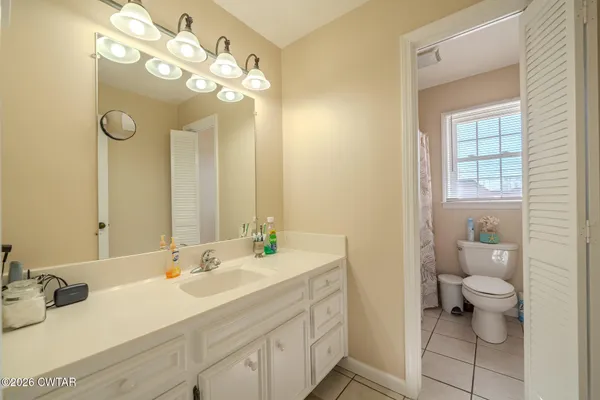 a bathroom with a sink vanity granite and toilet