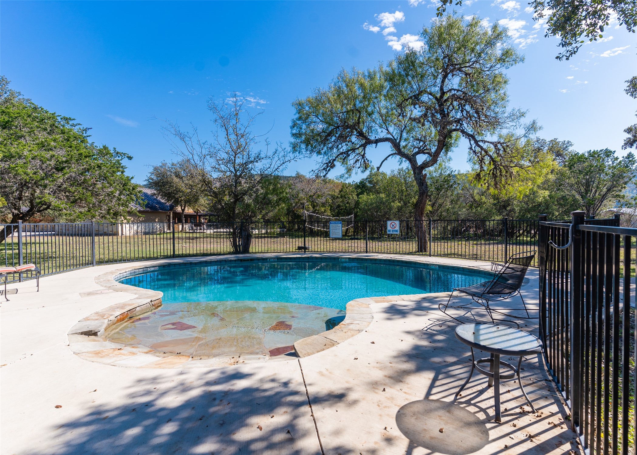 72 Stepping Stone Lane Concan, TX 78838 - Photo 3 of 25 a view of swimming pool with chairs and wooden fence
