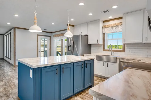 a kitchen with a sink kitchen island and stainless steel appliances