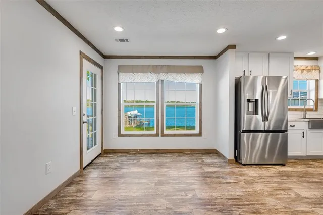 a view of kitchen with stainless steel appliances granite countertop a refrigerator and a sink