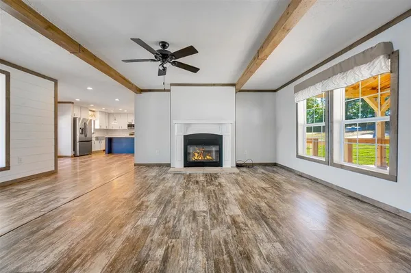 a view of empty room with wooden floor and fireplace