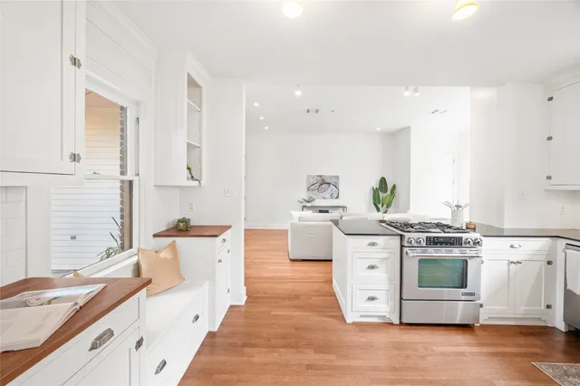 a kitchen with stainless steel appliances white cabinets and wooden floors