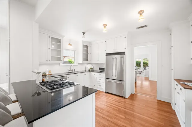 a kitchen with stainless steel appliances granite countertop a refrigerator stove top oven and sink