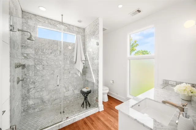 a bathroom with a granite countertop shower a sink and a mirror