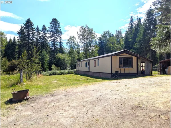 a front view of a house with a yard and trees