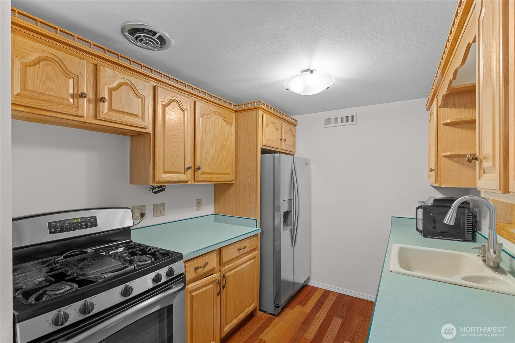1306 Southwest 160th Street Burien, WA 98166 - Photo 10 of 29 a kitchen with stainless steel appliances granite countertop a sink stove and refrigerator