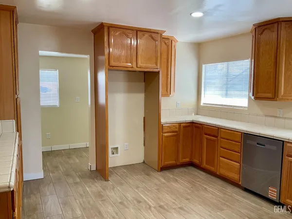 a view of a kitchen with wooden floor and cabinets