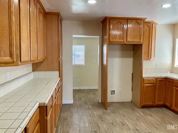 an empty room with wooden floor and cabinet
