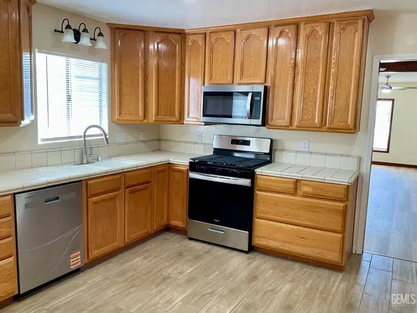 a kitchen with stainless steel appliances granite countertop a stove a sink and a microwave