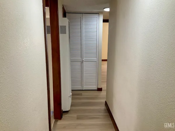 a view of a hallway with wooden floor and staircase