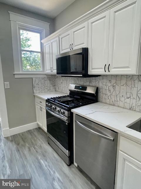 4041 West Cold Spring Lane Baltimore, MD 21215 - Photo 10 of 37 a kitchen with stainless steel appliances white cabinets and a stove top oven